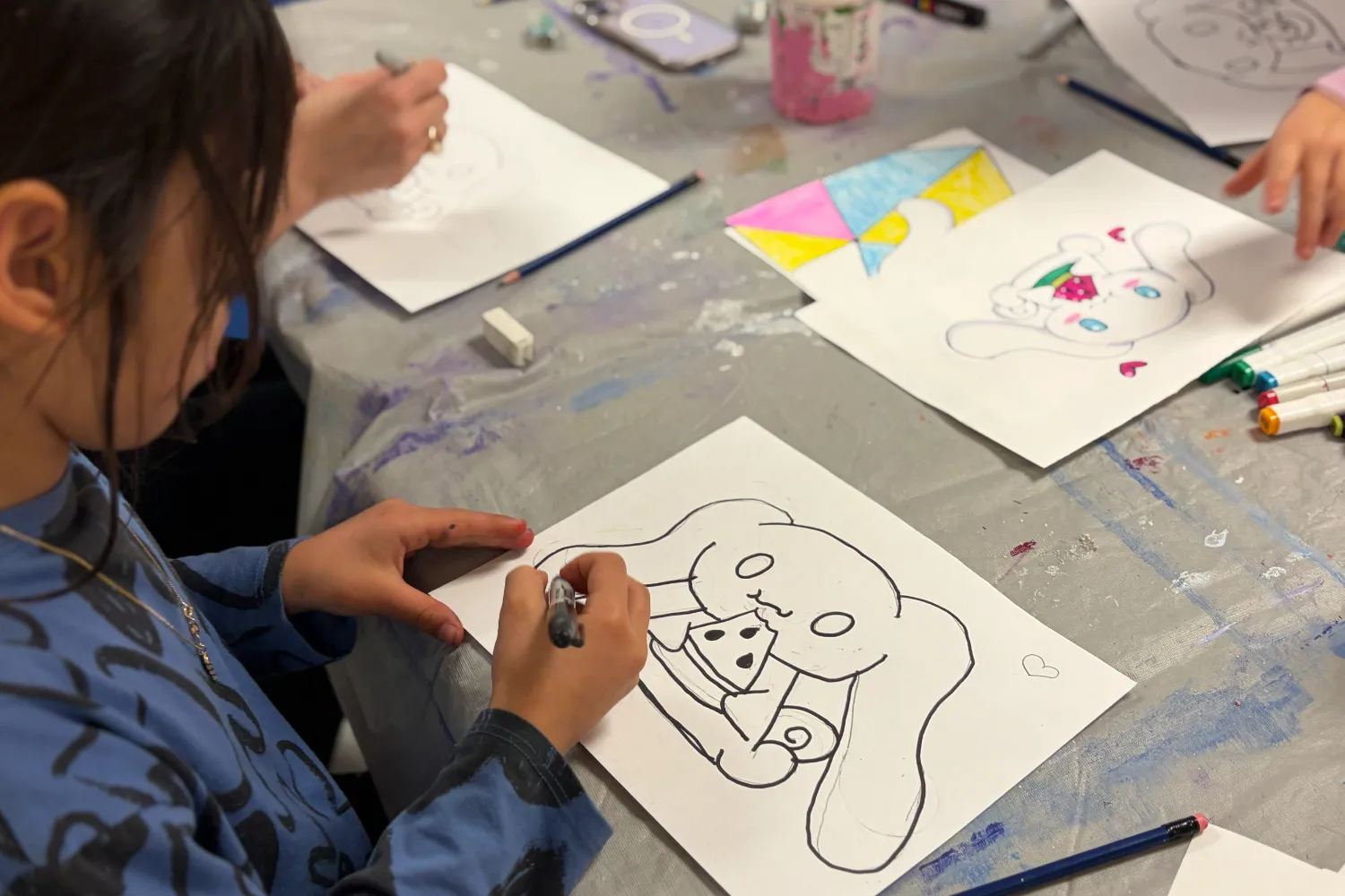Kids art class student at Avenue Road Arts School drawing colorful characters in Toronto.