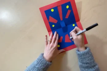 Card background with red tapered strips and coloured paper circles arranged for visual balance