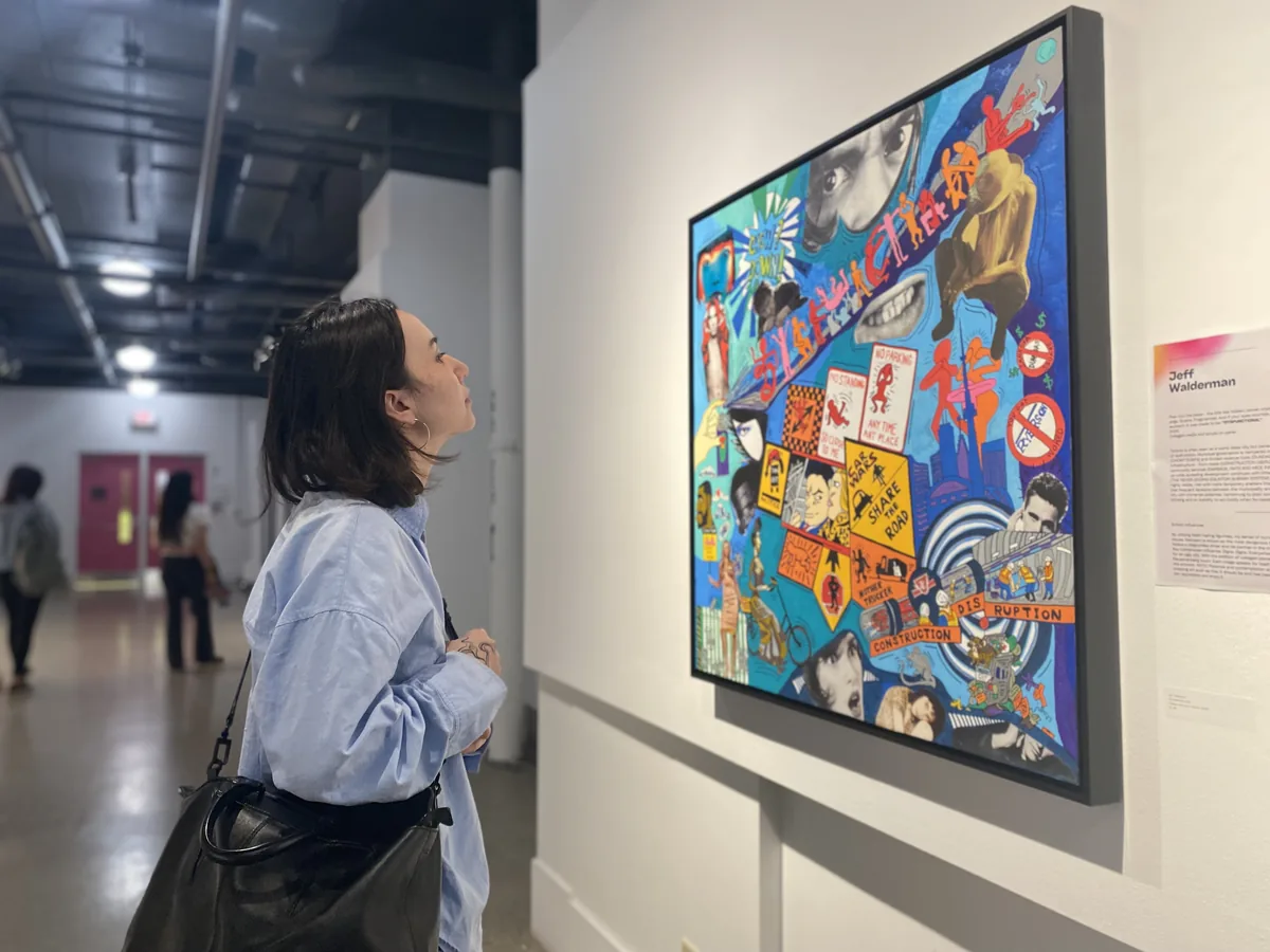 aras-summer-inside-the-exhibition-2026 Gallery visitor looking up at a large vibrant mixed-media painting on a white gallery wall — Avenue Road Arts School Inside the Exhibition course