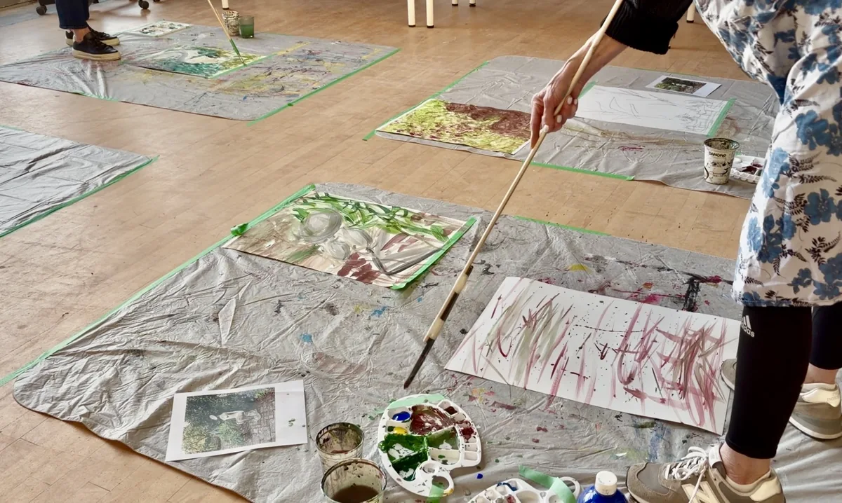 aras-summer-painting-big-from-nature-2026 Large canvases laid flat on a studio floor with artists painting expressive works from nature reference photos using long-handled brushes — Avenue Road Arts School Painting BIG from Nature course
